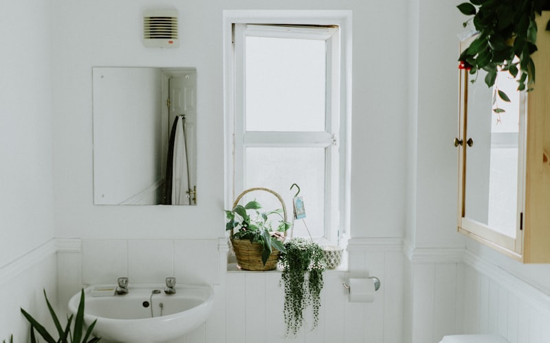 Freshly cleaned bright bathroom with white tile and modern fixtures